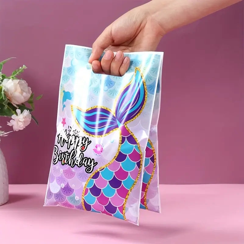 Hand holding a mermaid-themed birthday gift bag with a pink background
